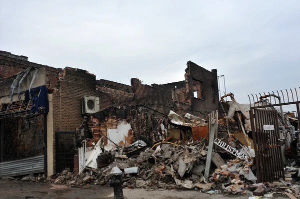 QUEENS, NY - NOVEMBER 11: working on buildings ruins ater massive fire in the Rockaway due to impact from Hurricane Sandy in Queens, New York, U.S., on Novemeber 11, 2012. — Stock Photo, Image