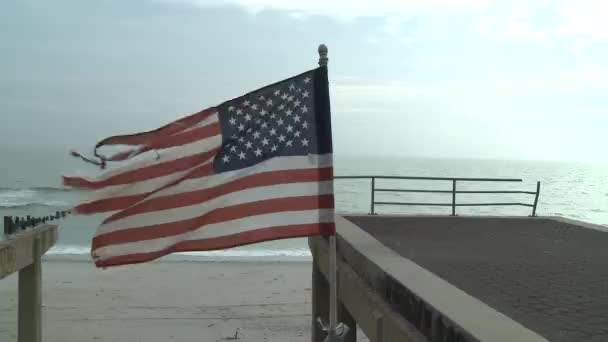 NOVA IORQUE, NY - NOVEMBRO 11: O calçadão destruído e uma bandeira americana esfarrapada após a supertempestade Sandy em Rockaway Beach em 11 de novembro de 2012 no bairro Queens de Nova York . — Vídeo de Stock