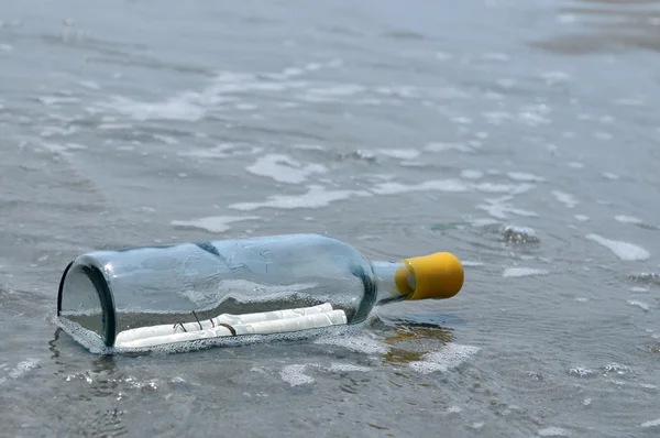 Mensaje en la botella en la arena y el océano en el fondo — Foto de Stock