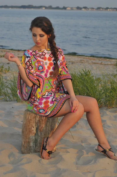 Beautiful brunette model posing pretty at tropical beach wearing short designers colorful dress — Stock Photo, Image