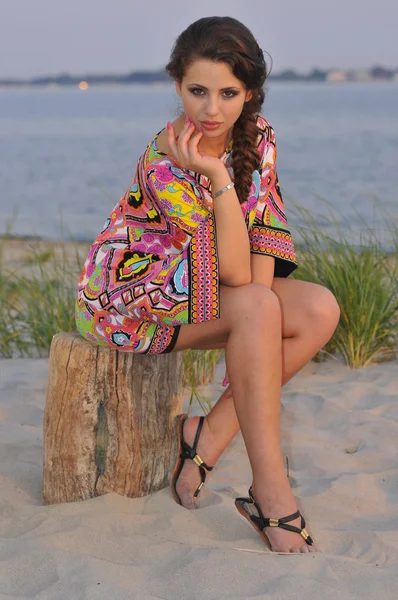 Beautiful brunette model posing pretty at tropical beach wearing short designers colorful dress — Stock Photo, Image