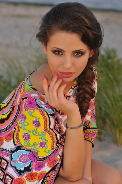 Krásná bruneta model představuje docela na tropické pláži barevné šaty krátké návrháři — Stock fotografie