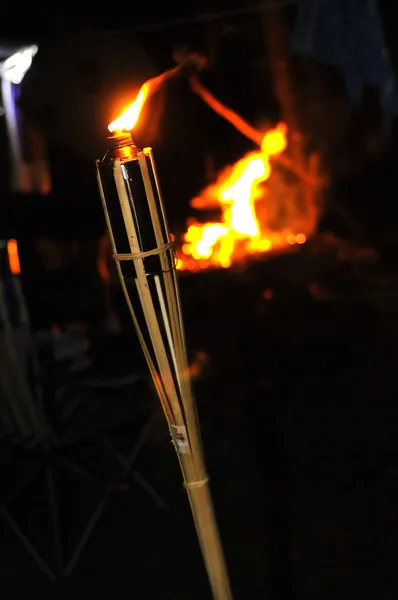 Kamp ateşi ve geceleri yanan bir bambu meşale alevi. — Stok fotoğraf