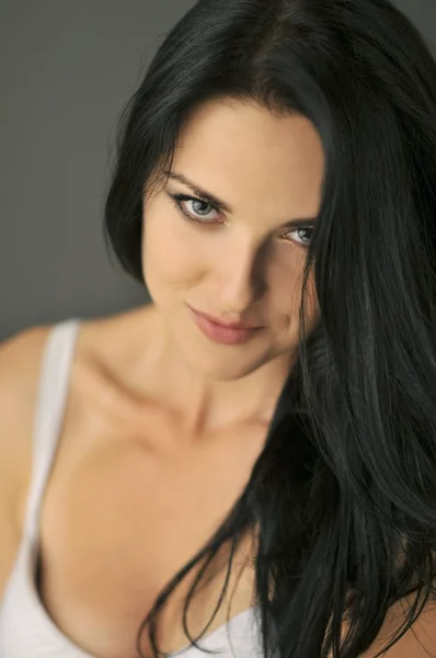 Attraktive lächelnde junge brünette Frau mit blauen Augen. geringe Schärfentiefe, Fokus auf die Augen. — Stockfoto