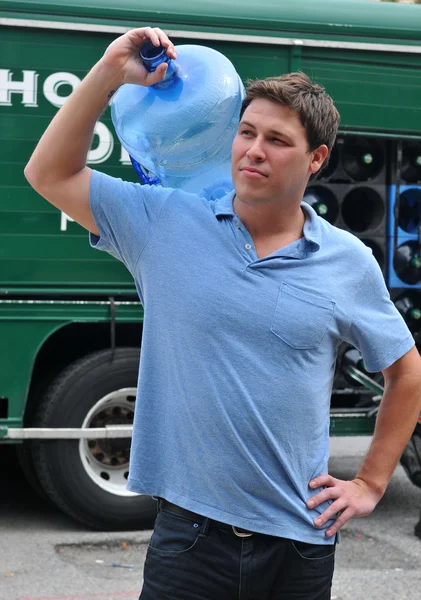Дружелюбный доставщик приносит 5 галлонных кувшинов воды — стоковое фото