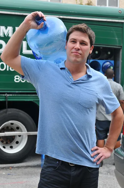 Vriendelijke levering man brengen 5 liter water kannen — Stockfoto