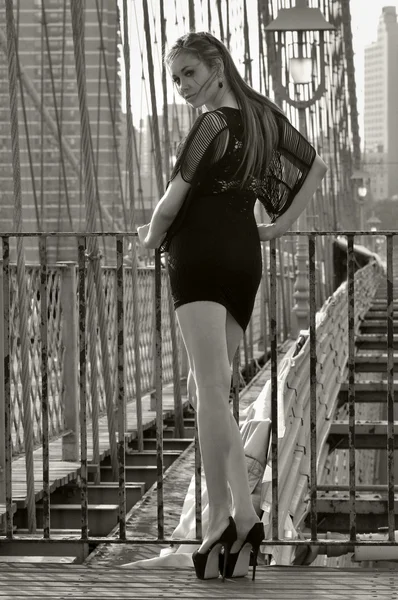 Modella in posa sexy in abito corto nero sul ponte di Brooklyn a New York — Foto Stock