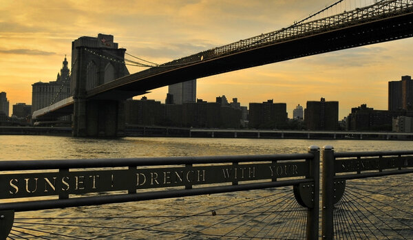 New York City evening skyline with Brooklyn Bridge over Hudson River