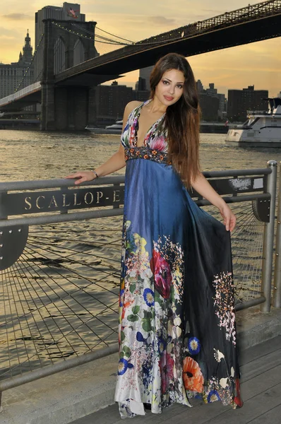 Fashion model posing in long blue dress in front of Brooklyn Bridge in New York City — Stock Photo, Image