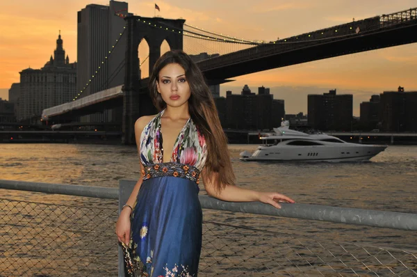 Modella in posa in abito lungo blu davanti al ponte di Brooklyn a New York — Foto Stock