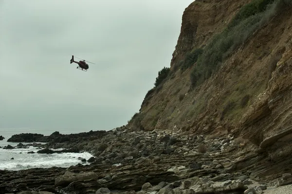 Helikopter vliegen over rotsachtige strand in palos verdes, ca — Stockfoto