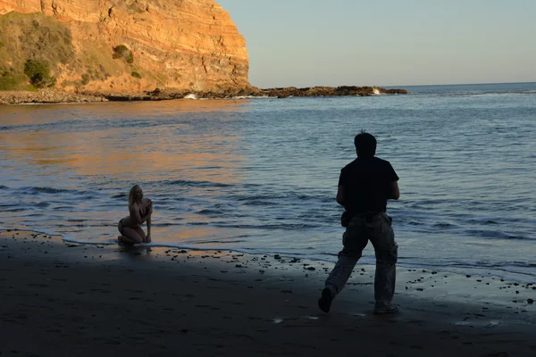 Fotograf fotografering bikini modell på solnedgången av den oceanphotographer skytte bikini modell på solnedgången vid havet — Stockfoto