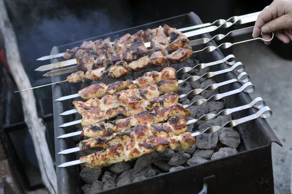 Carne em espetos sendo queimado em um churrasco — Fotografia de Stock