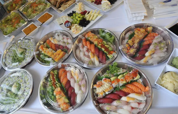 Sushi, sashimi, rollos en bandejas y bocadillos fríos — Foto de Stock
