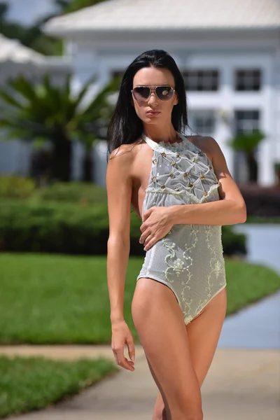 Modelka v plavkách návrháři pózuje před domem — Stock fotografie