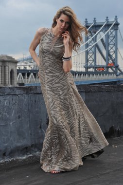 model üzerinde çatı katındaki konumu ile metal köprü inşaatı zemin üzerine uzun gece elbisesi giymiş seksi poz moda