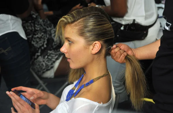 Modèle pendant le processus de coiffure et de maquillage et regarde d'abord les coulisses de la collection Agua Bendita — Photo