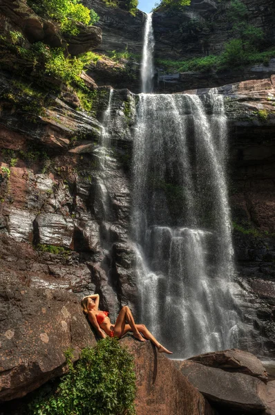 Hermoso modelo de fitness delgado posando sexy frente a las cascadas —  Fotos de Stock