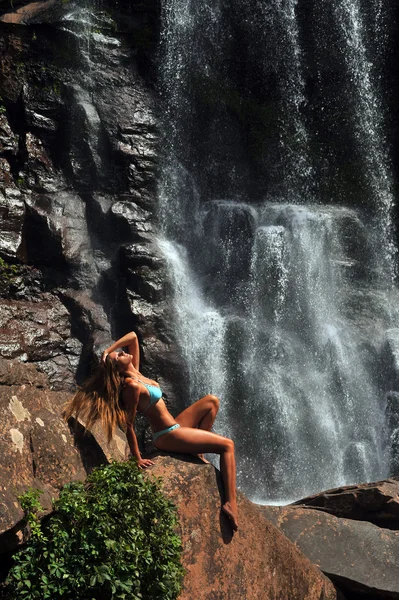 Vacker smal fitness modell poserar sexigt framför vattenfall — Stockfoto