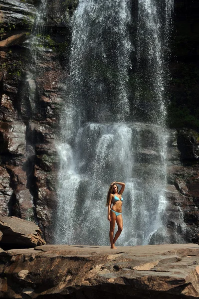 Modelo de fitness magro bonito posando sexy na frente de cachoeiras — Fotografia de Stock