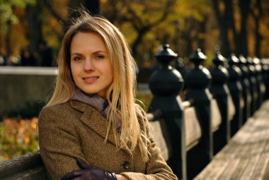 sonbahar bir parkta bankta oturmuş güzel zarif kadın