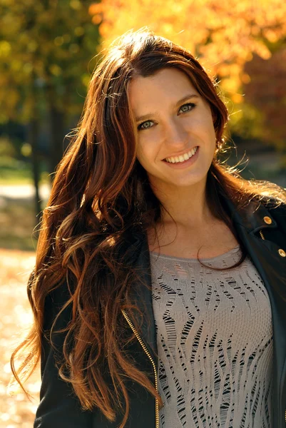 Beautiful elegant woman standing in a autumnal park — Stock Photo, Image