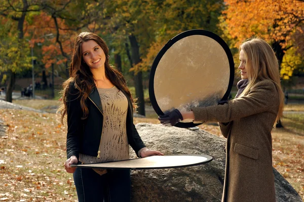 Two beautiful elegant girls holding photo reflectors — Stock Photo, Image