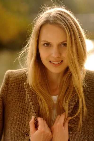 Beautiful elegant woman standing in a autumnal park — Stock Photo, Image