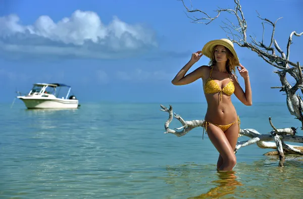 Modèle de bikini en chapeau de paille posant sexy devant la caméra à la plage tropicale — Photo