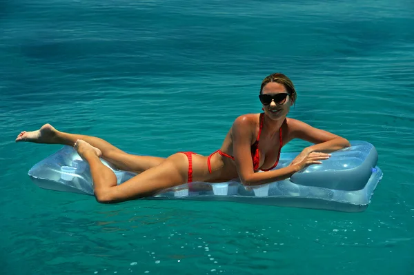 Woman in red bikini on floating device — Stock Photo, Image