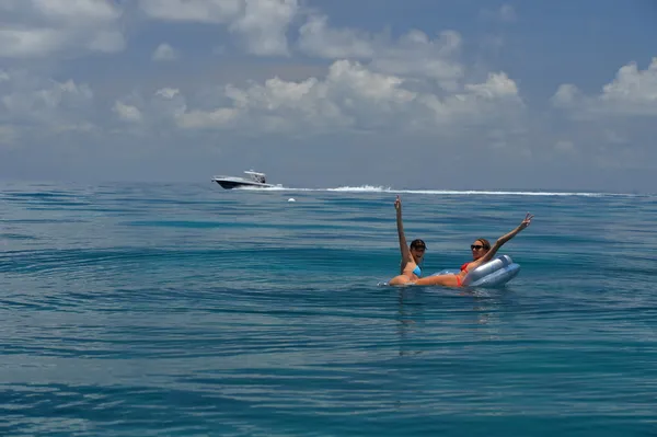Dos chicas en bikini en dispositivo flotante —  Fotos de Stock