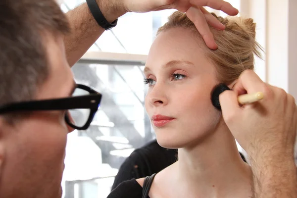 Makeup artist applying makeup to model — Stock Photo, Image