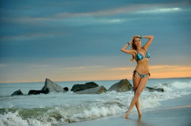 gün batımı sırasında sahilde bikinili kadın