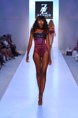Model walks runway at AZ Araujo Swimwear collection clipart