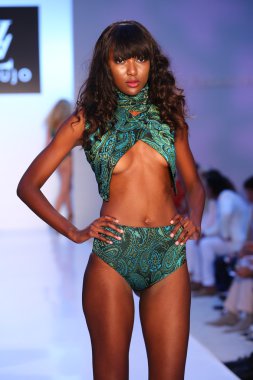 Model walks runway at AZ Araujo Swimwear collection clipart