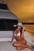 Model posing on deck of luxury yacht