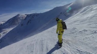 Çift elmaslı bölgede snowboard yapan sarı takım elbiseli bir adam..