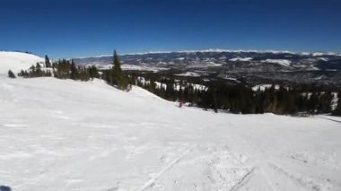 Kırmızı ceketli kayakçı Breckenridge Kayak Merkezi Colorado 'da yokuş aşağı gidiyor..