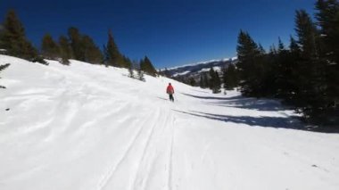 Kırmızı ceketli kayakçı Breckenridge Kayak Merkezi Colorado 'da yokuş aşağı gidiyor..