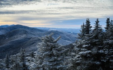 Scenic winter mountains landscape. Pine trees covered with snow. Stowe, Vermont.