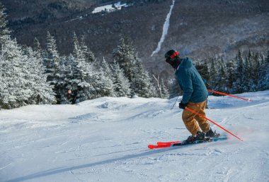 Man skier skiing down the slope. Extreme winter sport. Stowe Mountain Resort, Vermont.