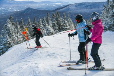 Skiers getting ready downhill at Peak Mansfield at Stowe Mountain Resort, Vermont. Diamond ski trail.