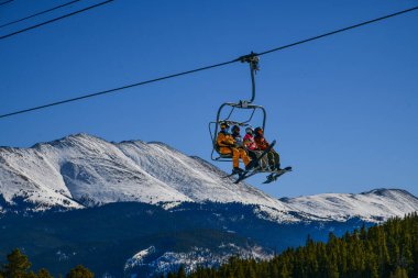 Colorado 'daki Breckenridge Kayak Merkezi' nde aktif spor yaşam tarzı ve kış tatili. İnsanlar güzel güneşli bir günde dağların zirvesine sandalyede biniyorlar..