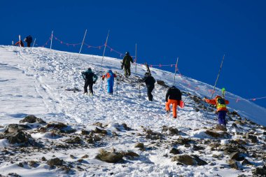 İmparatorluk Ekspres sandalyesinden tırmanan kayakçılar tepenin zirvesine çıkmak için dağın tepesine çıkıyorlar. Breckenridge Kayak Tesisi, Colorado.