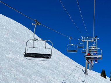 Chair lift at Ski Resort. Beautiful winter day with perfect sunny weather, clean blue sky. clipart