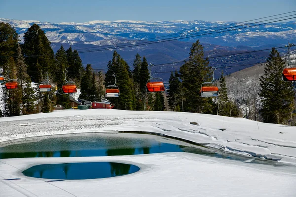 ユタ州のパークシティキャニオンスキー場でオレンジバブルチェアリフト 晩春の気象条件 山と池の範囲で谷への眺め — ストック写真