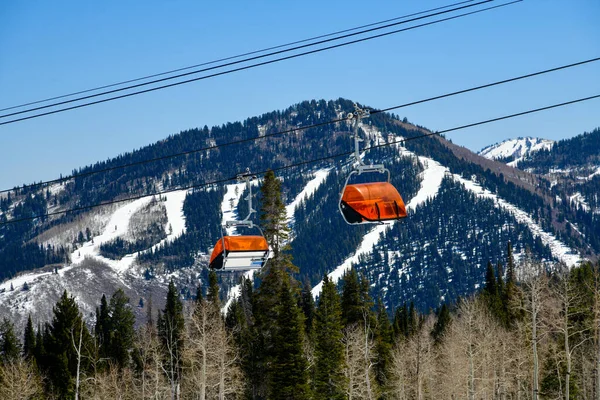 犹他州公园城峡谷滑雪区橙色泡泡椅电梯 晚春气候条件 有滑雪场的高山背景 — 图库照片