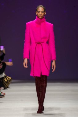 MİLAN, İTALYA - 24 Şubat 2022 'de Milano Moda Haftası / Kış 2023' te İtalya 'nın Milano kentinde düzenlenen Genny defilesinde bir model podyumda yürüyor..