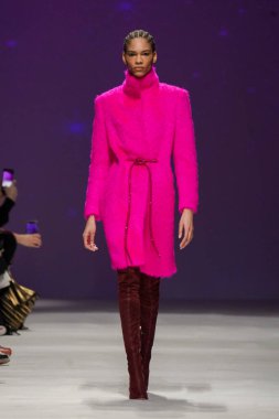 MİLAN, İTALYA - 24 Şubat 2022 'de Milano Moda Haftası / Kış 2023' te İtalya 'nın Milano kentinde düzenlenen Genny defilesinde bir model podyumda yürüyor..