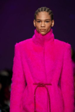 MİLAN, İTALYA - 24 Şubat 2022 'de Milano Moda Haftası / Kış 2023' te İtalya 'nın Milano kentinde düzenlenen Genny defilesinde bir model podyumda yürüyor..